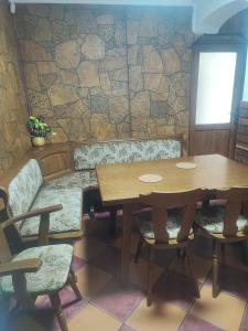 a dining room with a wooden table and chairs at Casa Luminita in Brezoi