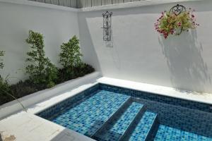 ジョムティエンビーチにあるDeva Casa Private Pool Villaのブルータイルフロアの庭園内のスイミングプール