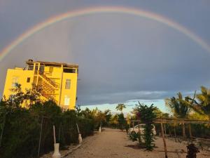 a rainbow in front of a yellow building at Five Seasons Zanzibar Ocean apartments in Muyuni
