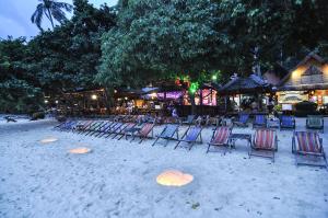 a group of chairs sitting on the sand on a beach at Phi Phi Relax Beach Resort in Phi Phi Islands