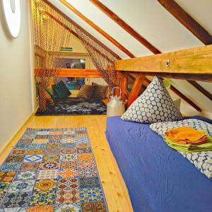 a attic room with two beds and a rug at Käsküche Bernbeuren anno 1890 in Bernbeuren