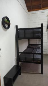 a black bunk bed with a hat on a wall at Chalés Cambury in Camburi