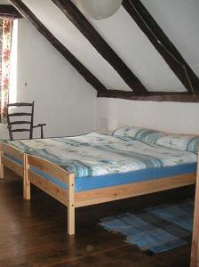 drewnianym łóżkiem w pokoju z krzesłem w obiekcie Casa Giulia w mieście Maggia