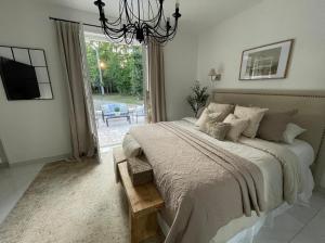 a bedroom with a large bed and a chandelier at Suite parentale in Lamorlaye