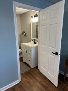 a bathroom with a sink and a white door at Relax on White Lake at Peninsula Point in Montague