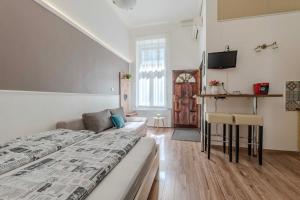 a bedroom with a bed and a couch and a tv at Mirage Apartments Váci Street in Budapest