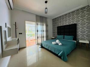 アシラにあるAsilah Marina Golf et vue sur l'océanのベッドルーム1室(ベッド1台、緑の掛け布団付) +33枚の写真