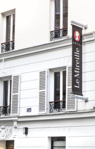 a sign for a hotel on the side of a building at Le Mireille in Paris