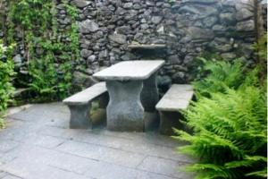 a stone bench sitting in front of a stone wall at Casa Giulia in Maggia