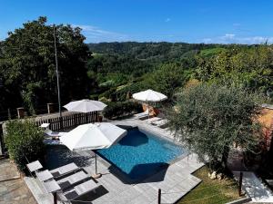 a swimming pool with umbrellas and lounge chairs at Belvedere Bike Hotel in Montà