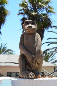 uma estátua de um urso sentado numa parede em Langholm Hotel em Walvis Bay