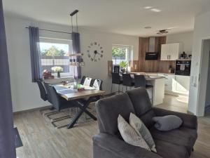 a living room and kitchen with a couch and a table at Fewo RoBBe in Wangerland