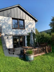 a small house with a porch and an umbrella at Ferienwohnung Losenberg in Olsberg