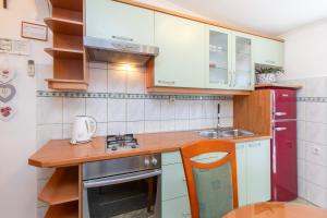 a small kitchen with white cabinets and a sink at Apartment Damir in Brodarica