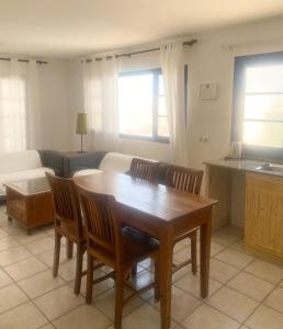 a living room with a table and chairs and a couch at Apartamento Vista Famara 2 in Famara