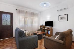 een woonkamer met twee stoelen en een televisie bij Casa Maria Beatriz in Manta Rota