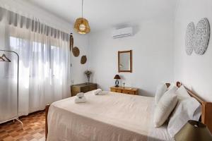 een slaapkamer met een wit bed en een raam bij Casa Maria Beatriz in Manta Rota +19 foto's