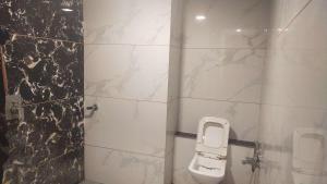 SitāpurHotel Rk Arcade的一间带卫生间和大理石墙的浴室