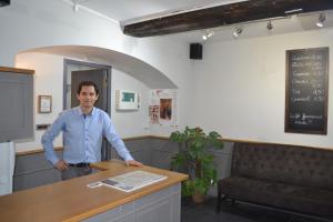 a man standing in front of a counter in a room at Hotel Concorde in Nîmes