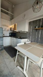 a white kitchen with a white table and a table and chairs at Söpö mökki Himoksella palveluiden vieressä in Jämsä +8 photos