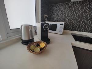 コタキナバルにあるAzumi Retreatの電子レンジとお金の入ったバスケットが置かれたキッチンカウンター