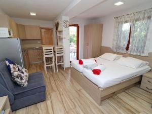 a bedroom with a large bed and a blue couch at Seaside Apartments Hrka - Studio Apartment with Terrace and Sea View 3 in Orebić