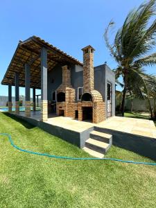 une maison avec une cheminée en briques dans une cour dans l'établissement Casa Brisa do mar, à Paracuru
