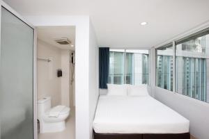 a small room with a bed and a toilet at Nantra Sukhumvit 39 in Bangkok