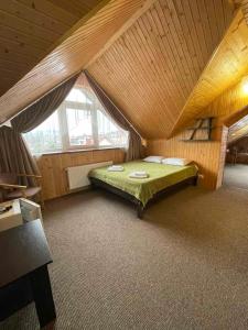 a bedroom with a green bed in a attic at Рутенія in Skhidnitsa