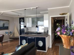 a kitchen and living room with a couch and a table at Queen Mary Maritim Residenz Travemünde in Lübeck