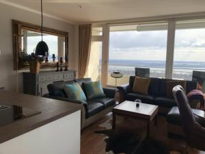 a living room with couches and a view of the ocean at Queen Mary Maritim Residenz Travemünde in Lübeck