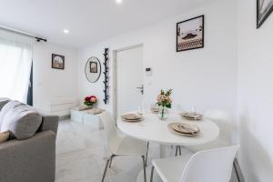 a white living room with a white table and chairs at Le Cosy proche Disney in Vaires-sur-Marne
