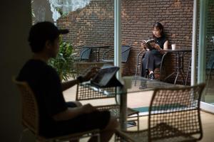a man and a woman sitting at a table reading at Nantra Sukhumvit 39 in Bangkok
