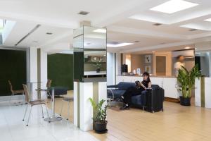 a woman sitting on a couch in a lobby at Nantra Sukhumvit 39 in Bangkok