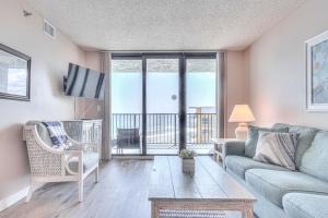a living room with a couch and a table at Ocean Trillium 803 - A 1 Bedroom Condo With Beautiful Ocean Views in New Smyrna Beach