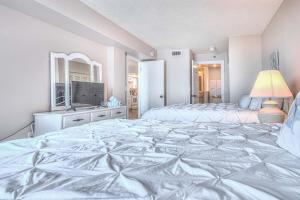 a large white bedroom with two beds and a television at Ocean Trillium 803 - A 1 Bedroom Condo With Beautiful Ocean Views in New Smyrna Beach +23 photos