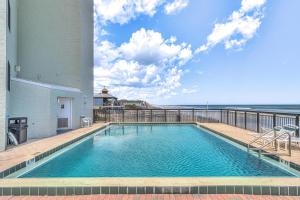 a swimming pool with a view of the ocean at Ocean Trillium 803 - A 1 Bedroom Condo With Beautiful Ocean Views in New Smyrna Beach