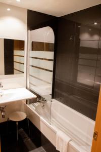 a bathroom with a shower and a sink and a tub at Hotel Escuela San Cristóbal in La Cistérniga +51 photos