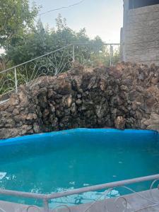 a rock wall next to a swimming pool at Stepanyans' Guest House in Areni