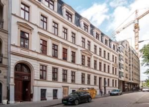 a large white building with cars parked in front of it at Apartment Eleven - Piekary Residence Stary Browar Old Town in Poznań
