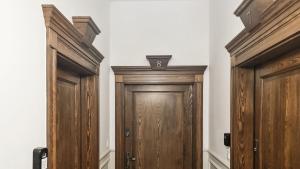 a pair of wooden doors in a room at Apartment Eleven - Piekary Residence Stary Browar Old Town in Poznań