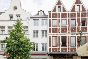 Un gran edificio blanco con un árbol delante. en Maisonette Wohnung Bolkerstraße in Düsseldorf, en Düsseldorf