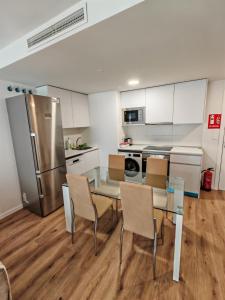 a kitchen with a table and chairs and a refrigerator at Rivas Futura in Rivas-Vaciamadrid