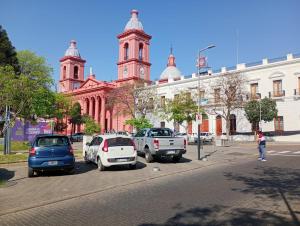 a street with cars parked in front of a building at Departamento a 150 metros de la catedral con cochera in San Fernando del Valle de Catamarca