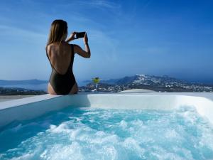 una mujer tomando una foto de un jacuzzi en Zannos Melathron, en Pirgos