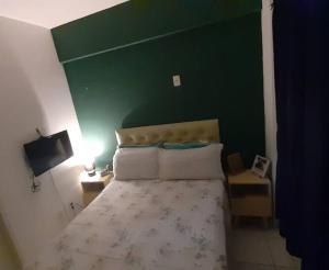Dormitorio verde con cama y pared verde en Apartamento em Messejana com lazer completa apto inteiro, en Fortaleza