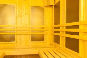 a wooden room with three windows and a bench at Gardenia Hotel & Spa in Veles
