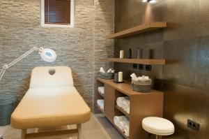 a bathroom with a chair and a desk with a lamp at Gardenia Hotel & Spa in Veles
