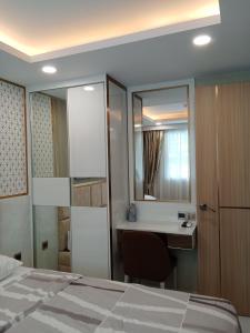 a bedroom with a bed and a desk and a mirror at Dusit grand park 2 in Jomtien Beach +2 photos