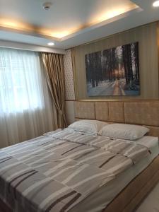 a large bed in a room with a window at Dusit grand park 2 in Jomtien Beach